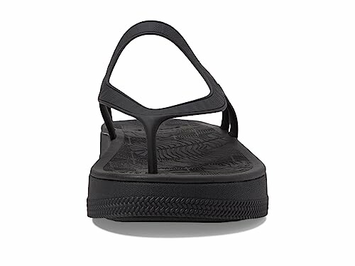 Front view of a black sandal with a textured sole