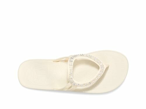 Top view of a white sandal with decorative strap.